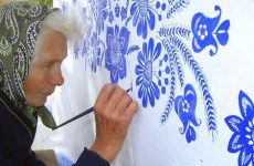 Бабушка рисует узоры на домах